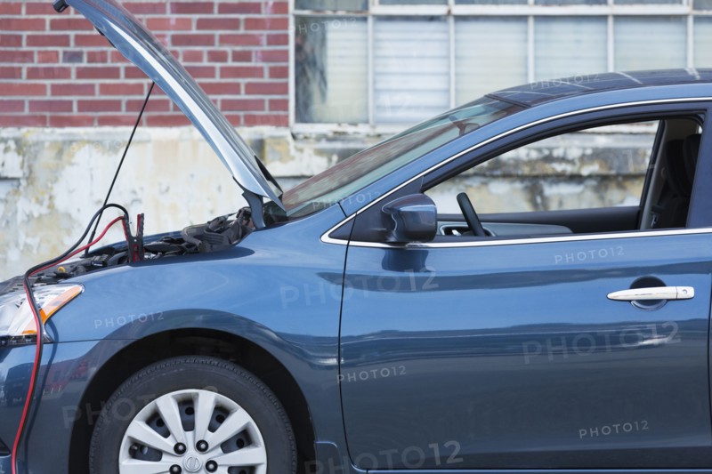 Empty broken down car with jumper cables