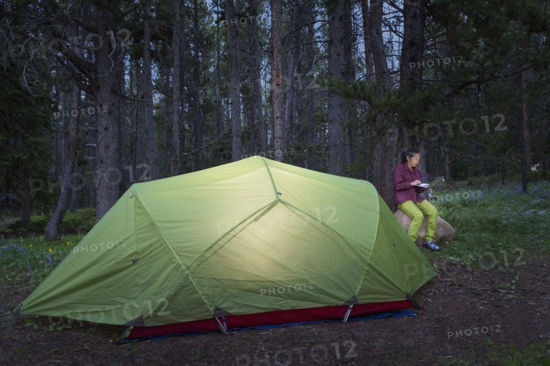 Japanese woman using laptop at campsite