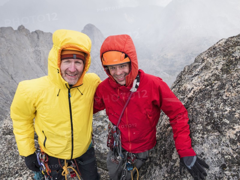 Caucasian climbers smiling on hillside