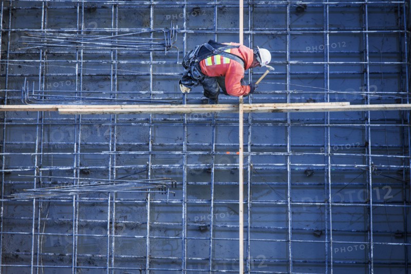 Caucasian worker nailing boards at construction site