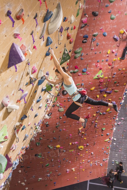 Caucasian woman climbing rock wall