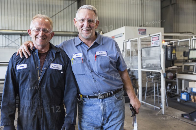 Smiling Caucasian workers posing in factory