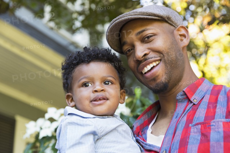 Smiling mixed race father holding baby son