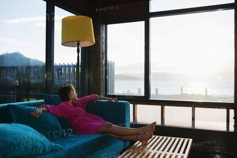 Mixed race girl looking out living room window