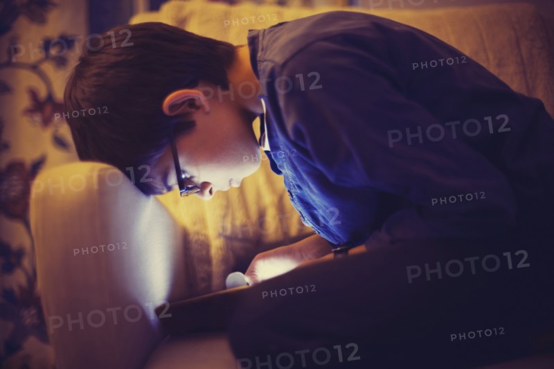 Mixed race boy using digital tablet on sofa