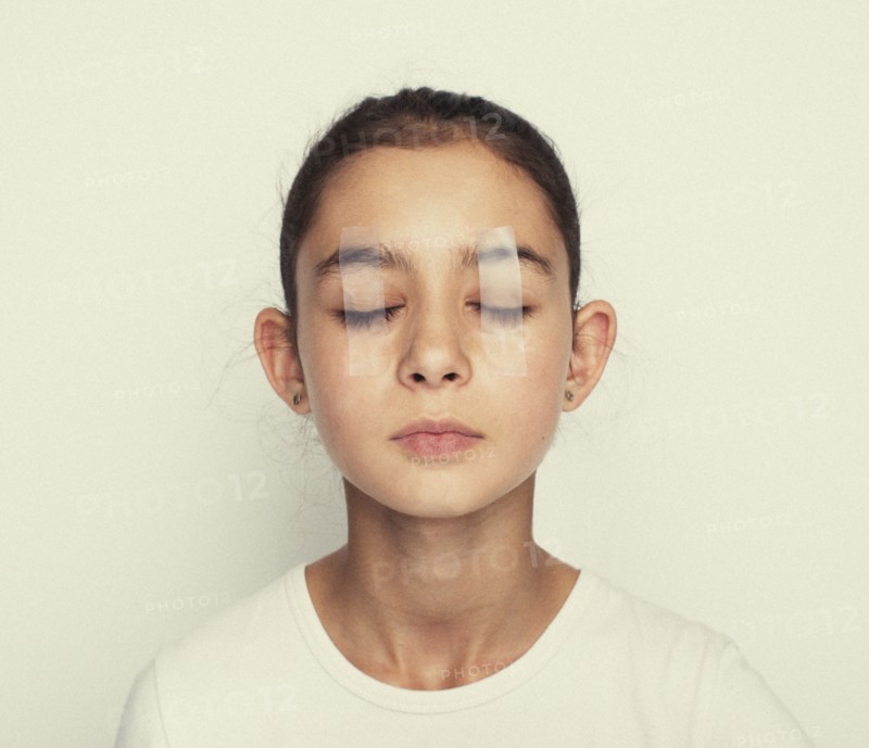 Mixed race girl with eyes taped shut