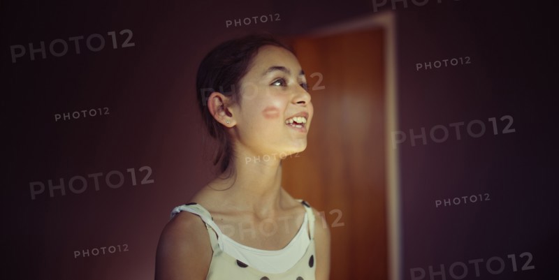 Mixed race girl with lipstick kiss on cheek