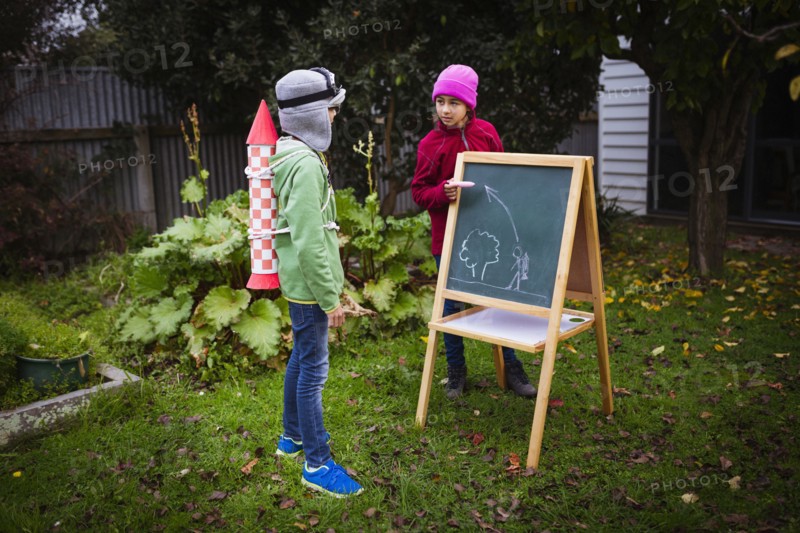 Mixed race children planning jetpack rocket
