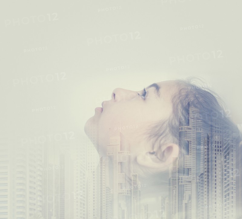 Double exposure of mixed race girl and cityscape