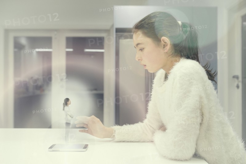 Mixed race girl examining hologram projection