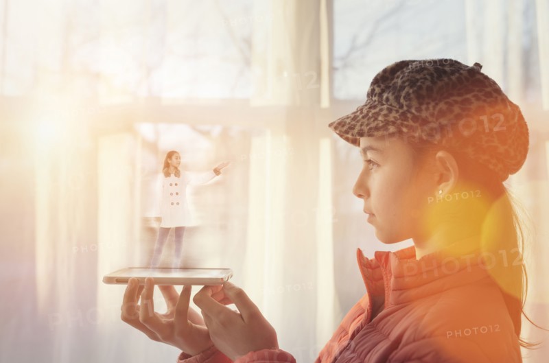 Mixed race girl examining hologram projection