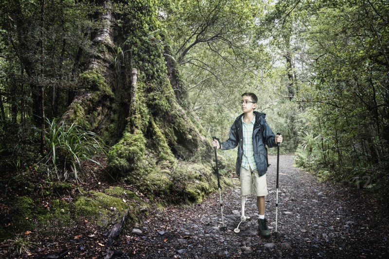 Mixed race boy hiking in forest