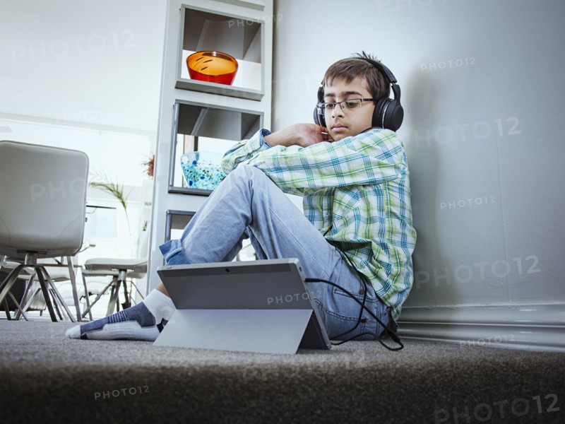 Mixed race boy using digital tablet on floor