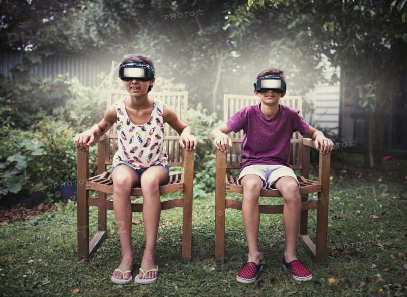 Mixed race children watching virtual reality screens