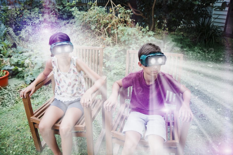 Mixed race children watching virtual reality screens