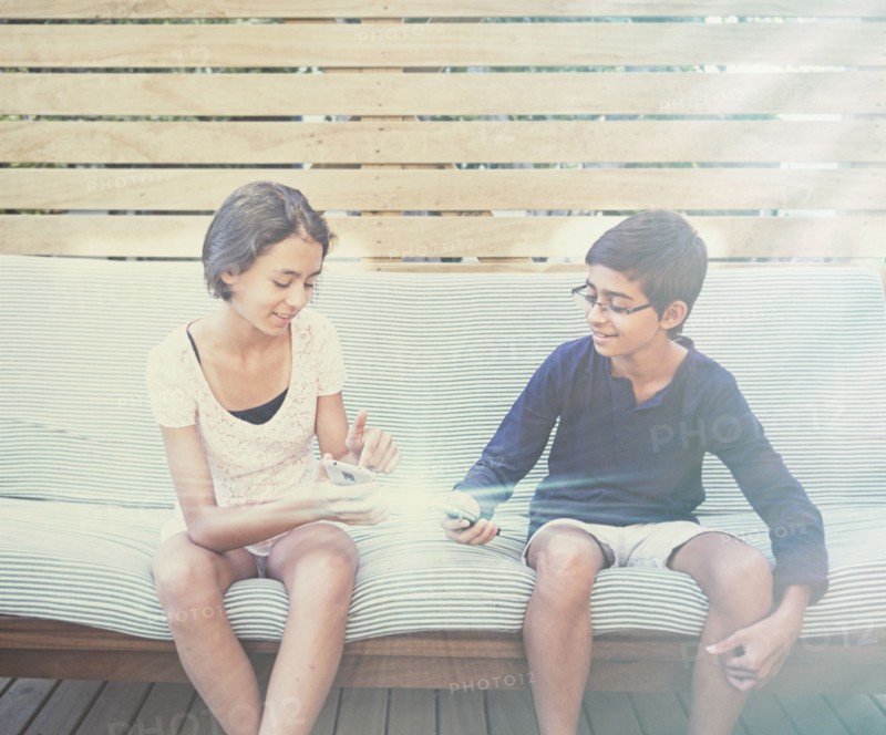 Mixed race children using glowing cell phones