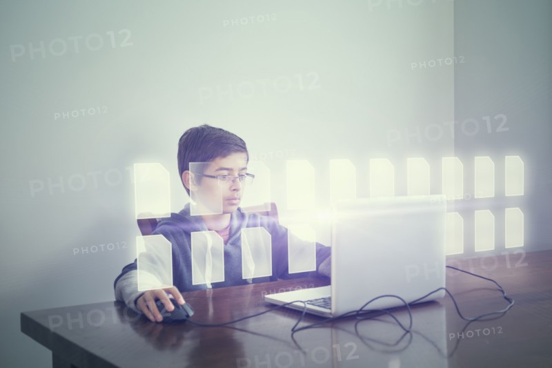 Mixed race boy using computer with holographic files