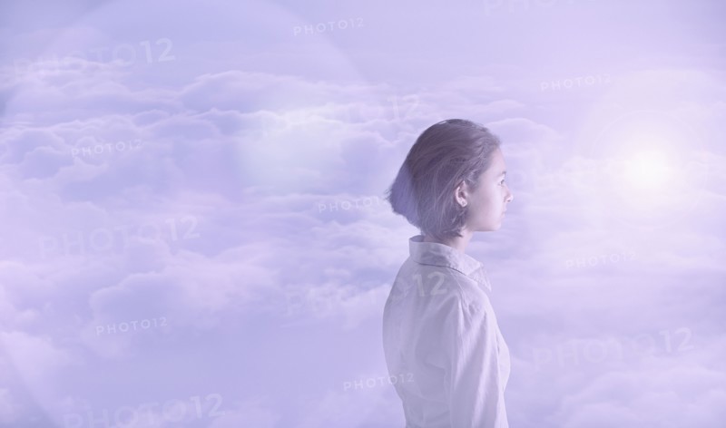 Pensive Mixed Race girl in clouds