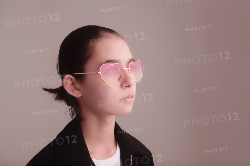 Mixed Race girl wearing heart-shape sunglasses