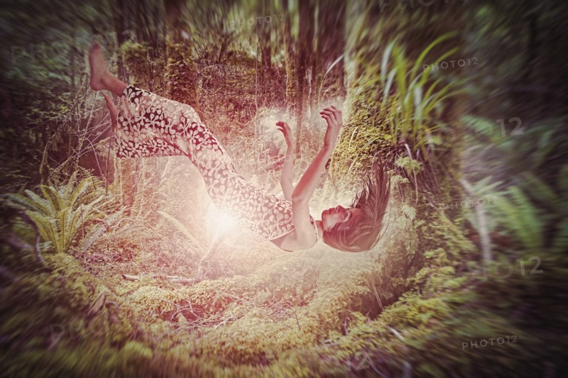 Mixed Race girl falling in glowing forest