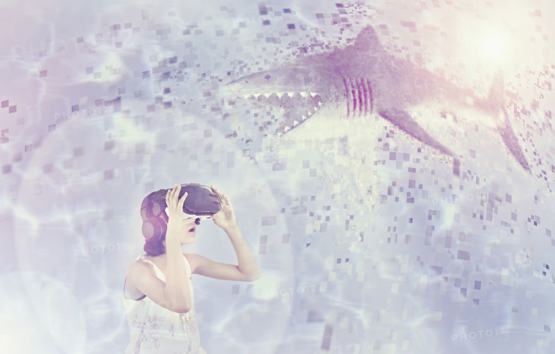Mixed Race girl using virtual reality goggles watching shark