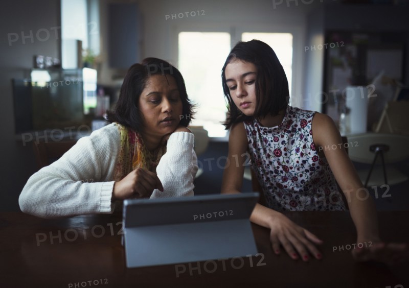Mother and daughter using digital tablet