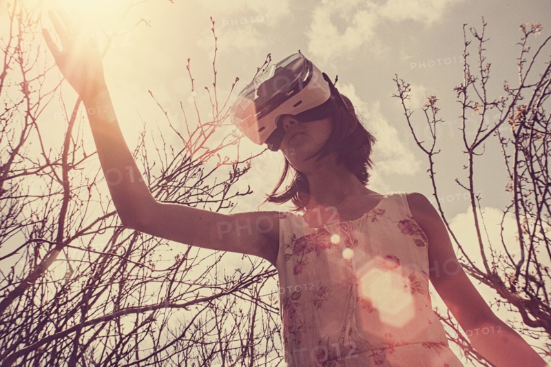 Mixed Race girl using virtual reality goggles outdoors