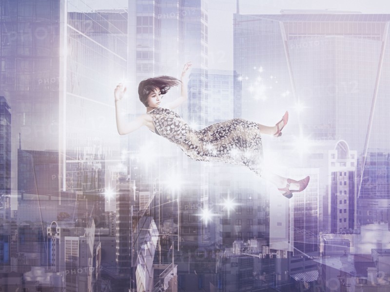 Mixed Race girl floating in city