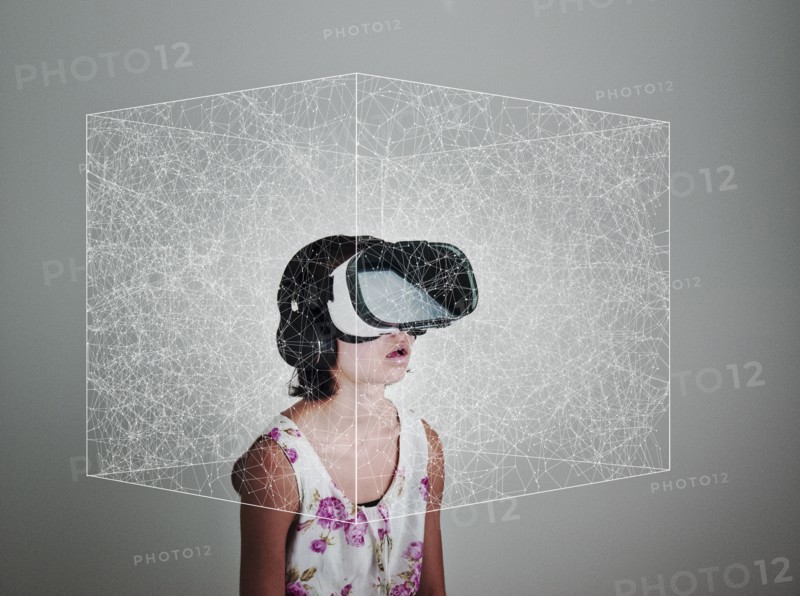 Mixed Race girl wearing virtual reality goggles in floating box