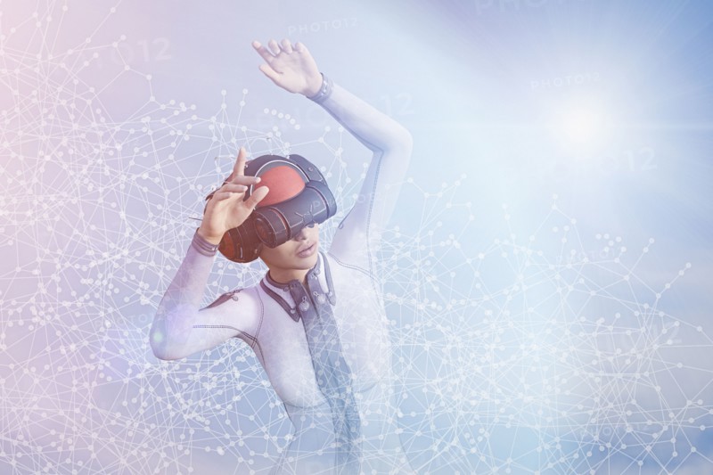 Woman with arms raised using virtual reality helmet