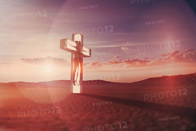 Person in suspended animation inside crucifix in desert
