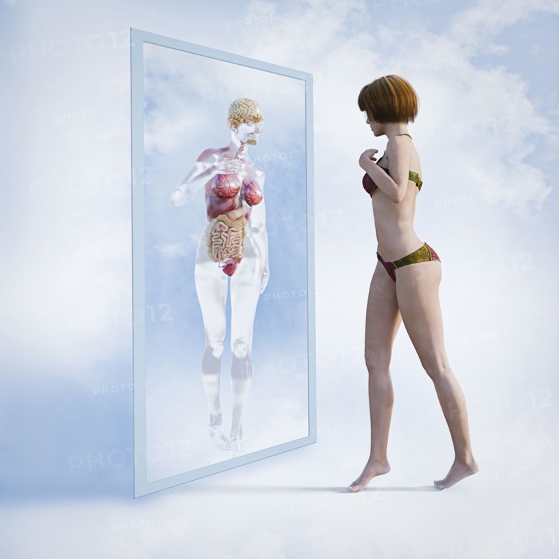 Woman examining reflection of organs in virtual mirror