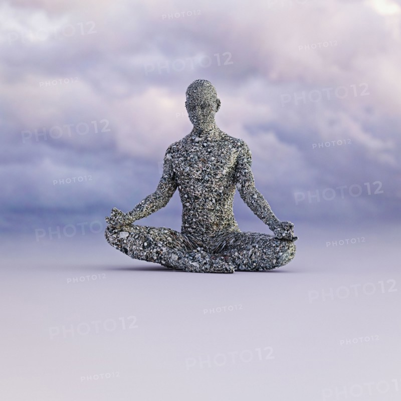 Stone man meditating under clouds