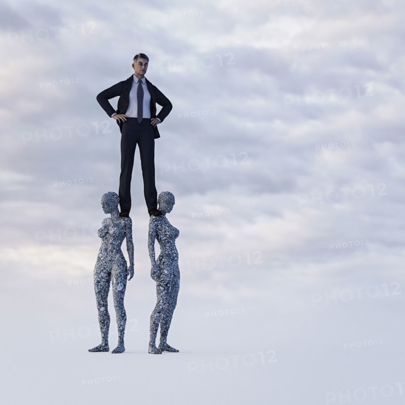 Businessman standing on shoulders of stone women