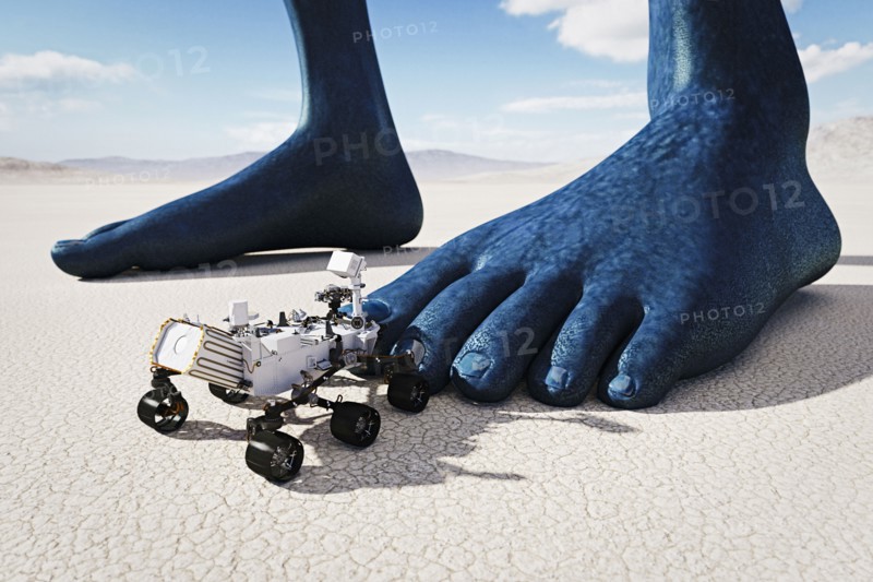 Small vehicle near feet of giant blue person