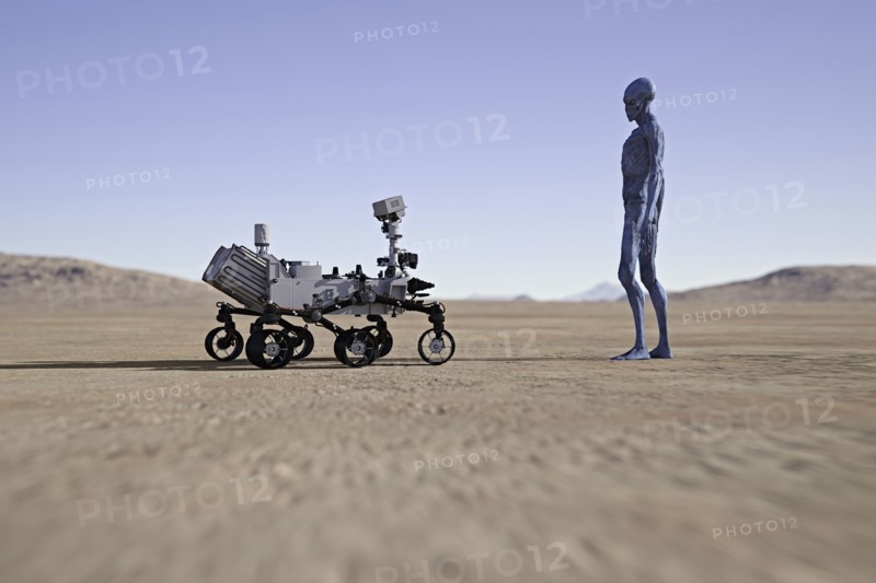 Alien watching small vehicle in desert
