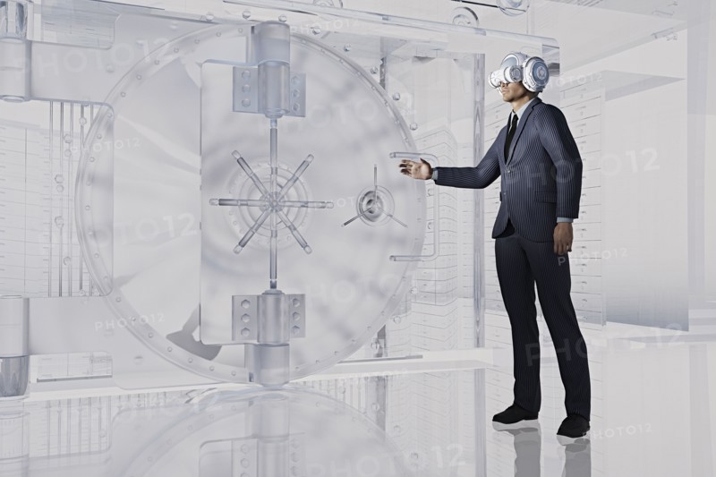 Businessman near vault wearing virtual reality goggles