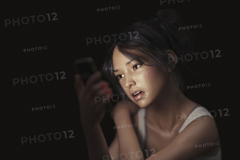 Girl texting on cell phone and crying