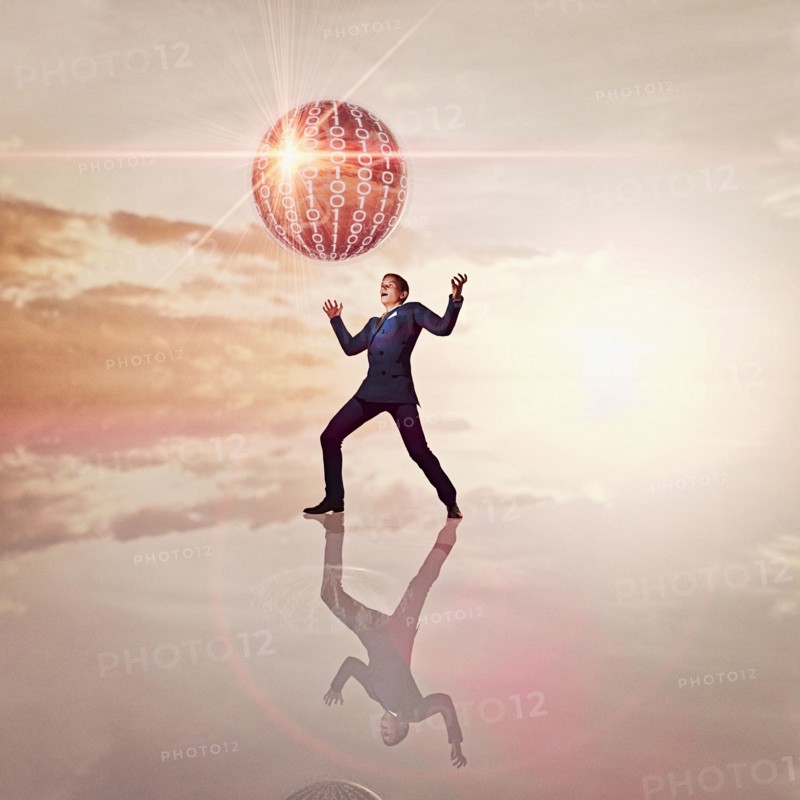 Businessman watching floating sphere of binary code