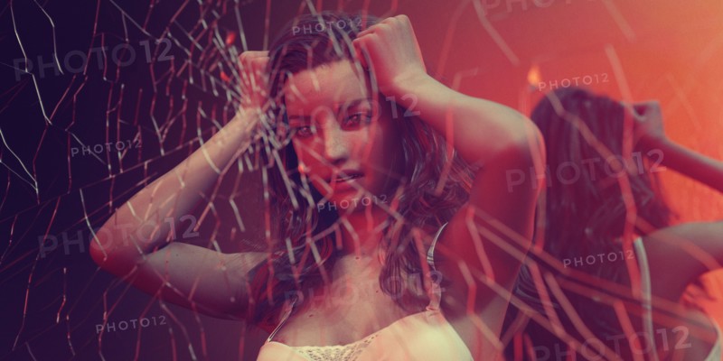 Frustrated woman behind breaking glass
