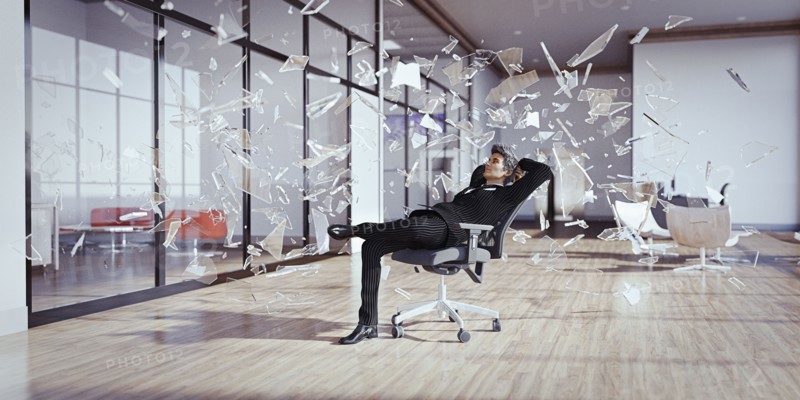 Businessman relaxing chair surrounded by shards of glass