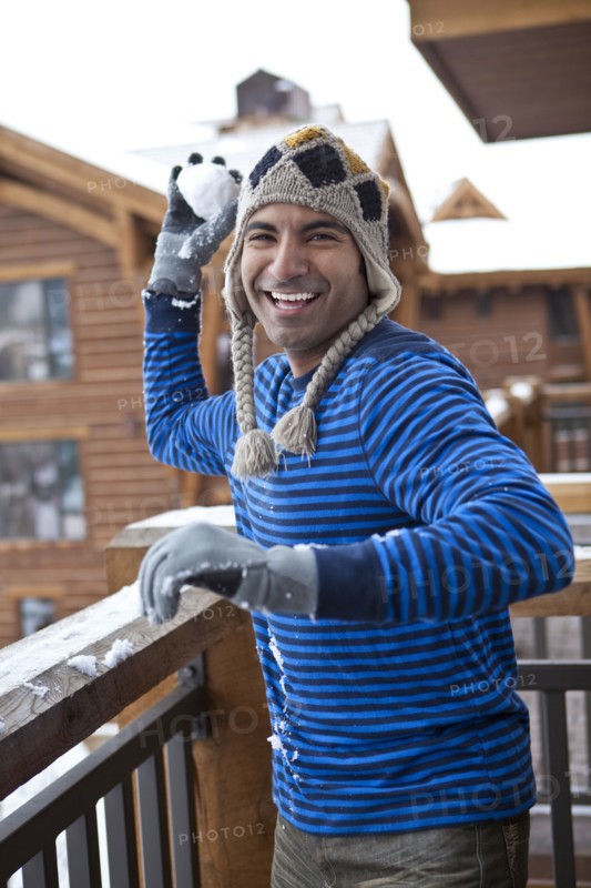 Smiling man throwing snowball
