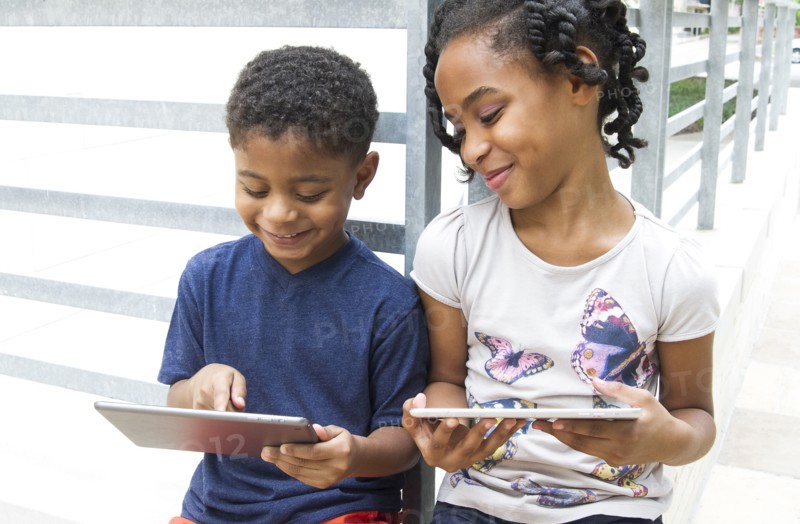 African American brother and sister using digital tablets