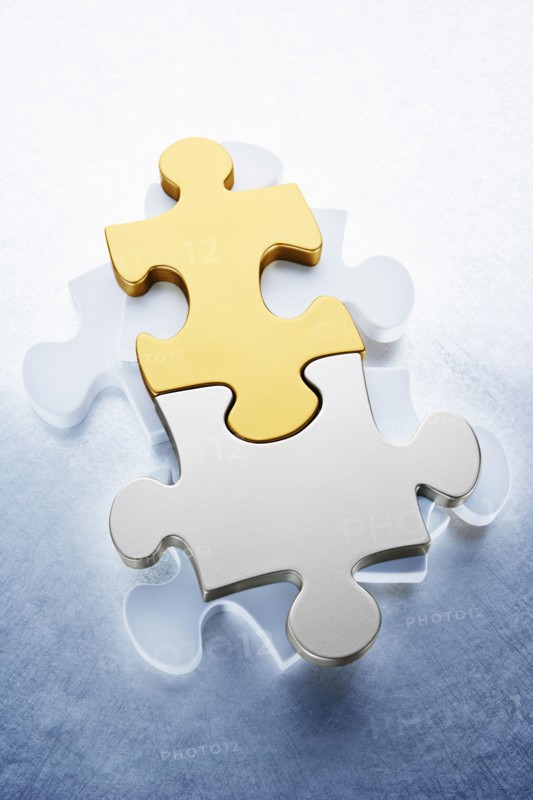 Close up of gold and silver puzzle pieces