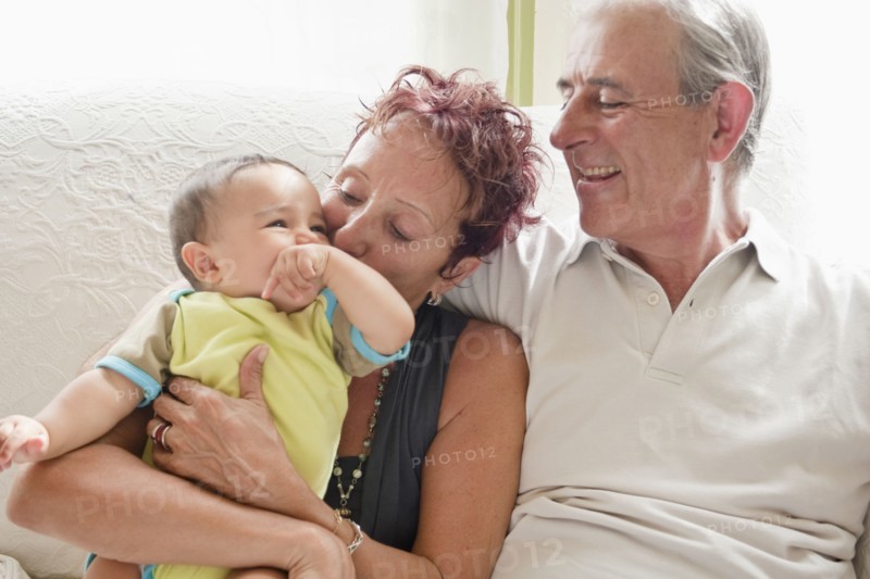 Couple holding baby on sofa