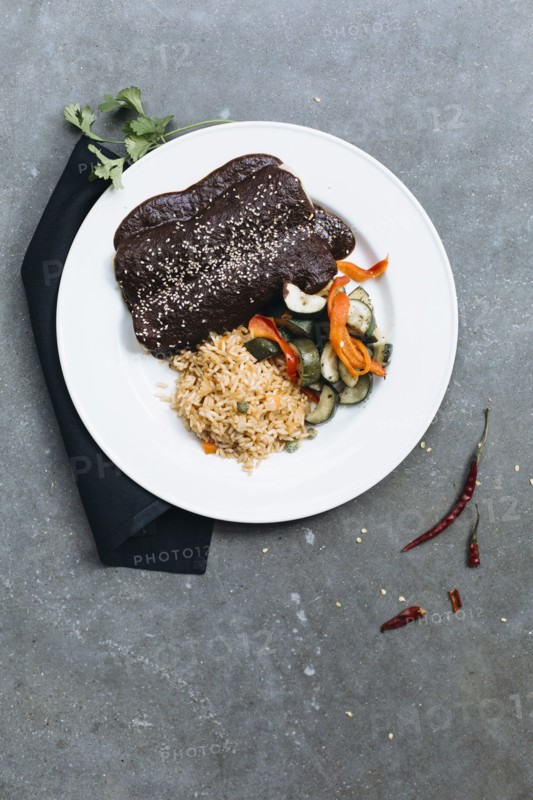 Plate of enchiladas with vegetables and rice