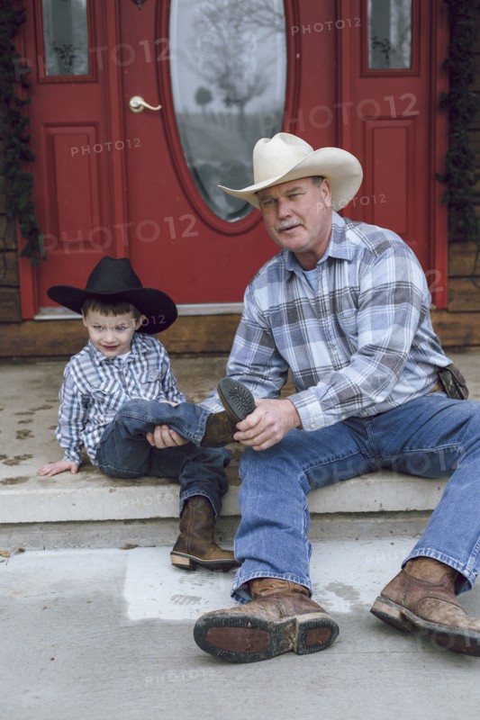 Caucasian farmer and grandson sitting on front porch