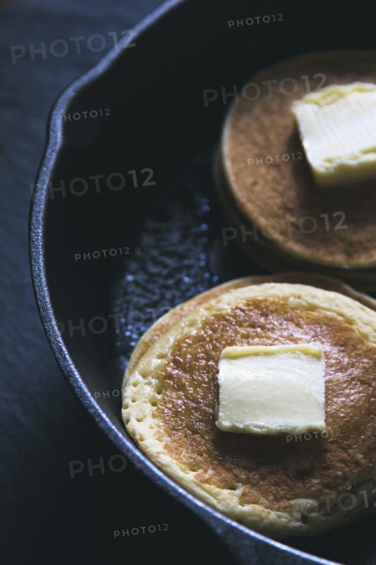Close up of butter on pancakes in pan