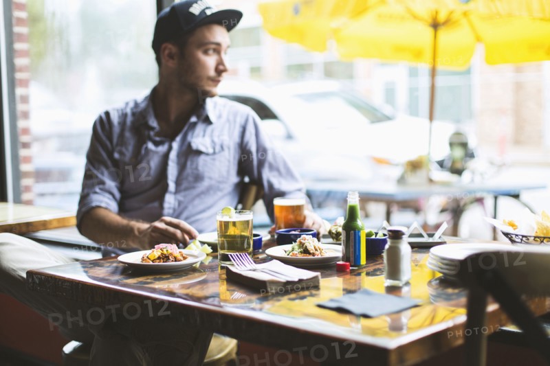 Caucasian man eating tacos in restaurant