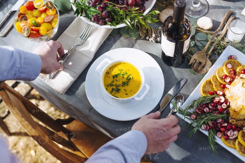 Caucasian man setting platter of soup on outdoor table